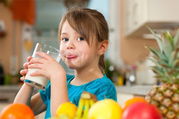 A girl drinks milk with the addition of Lactobacterin