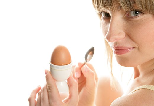 девушка держит куриное яйцо