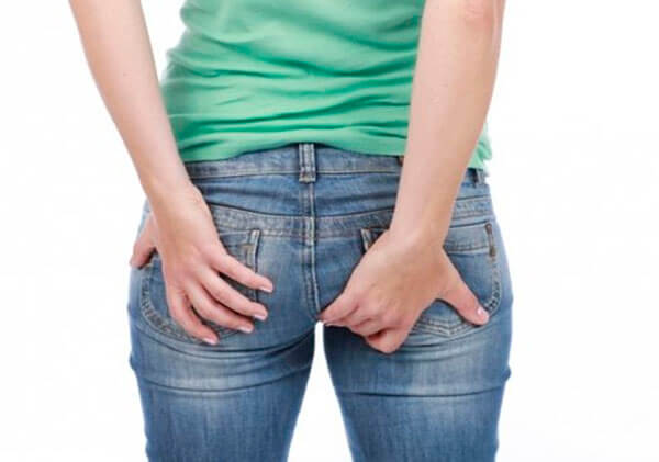 Girl holding her buttocks