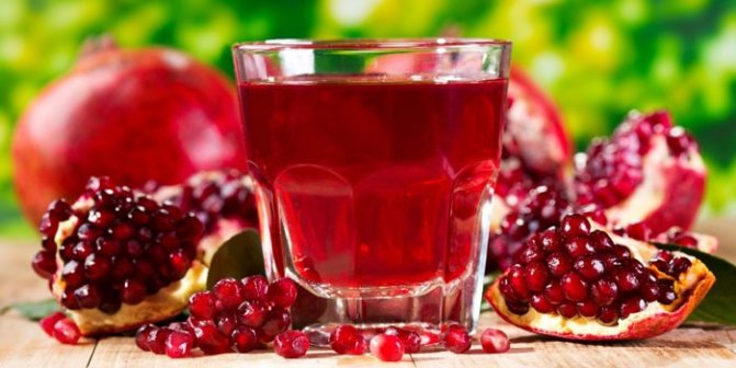 Pomegranate juice in a glass and pomegranates