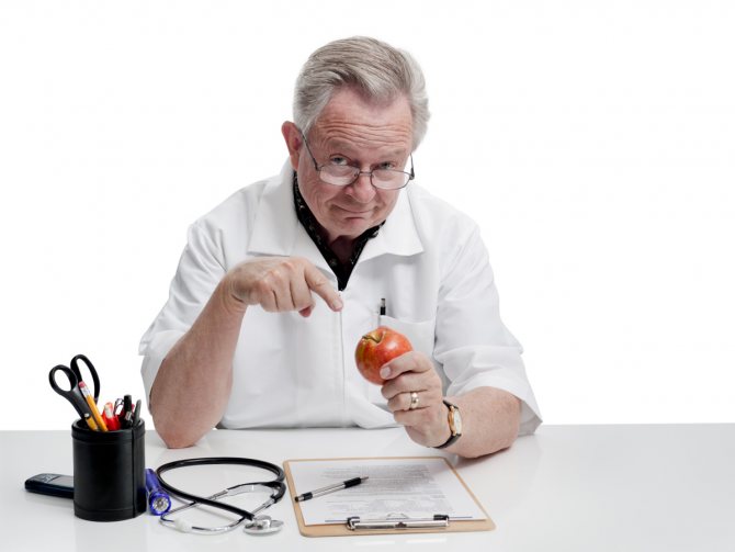 Doctor with glasses points to an apple
